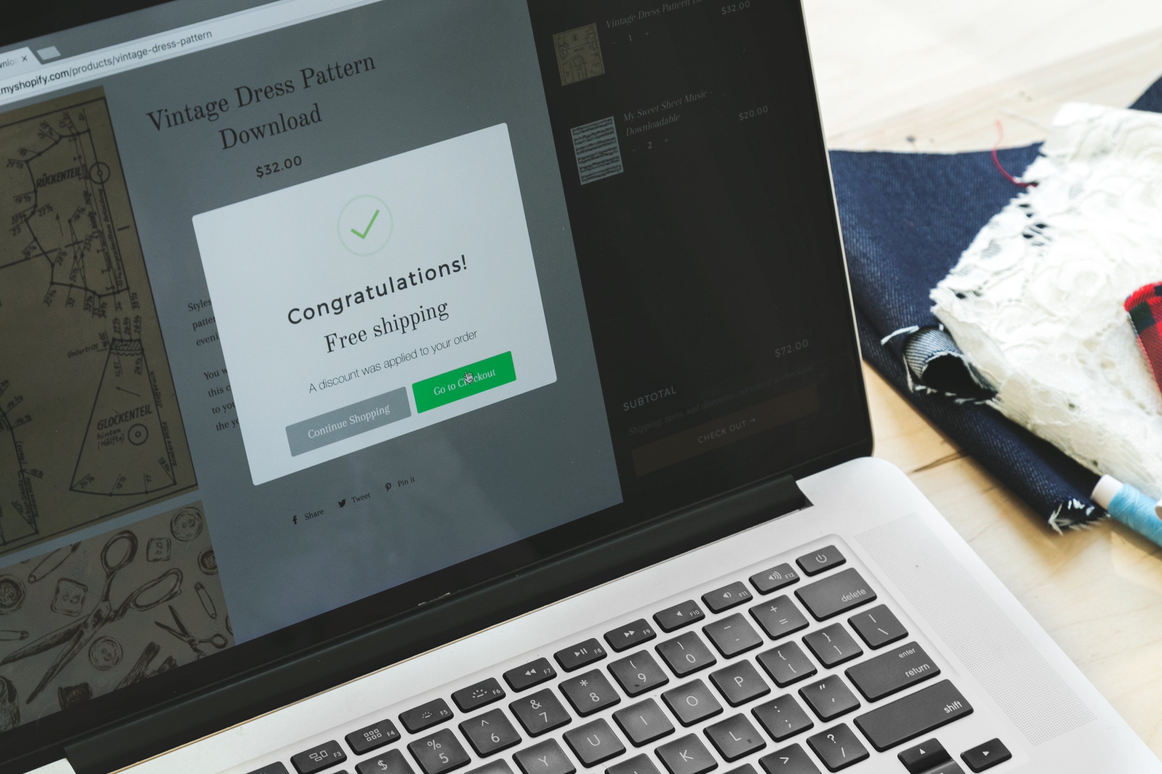 Laptop displaying a Shopify product page with a free shipping offer and checkout button.