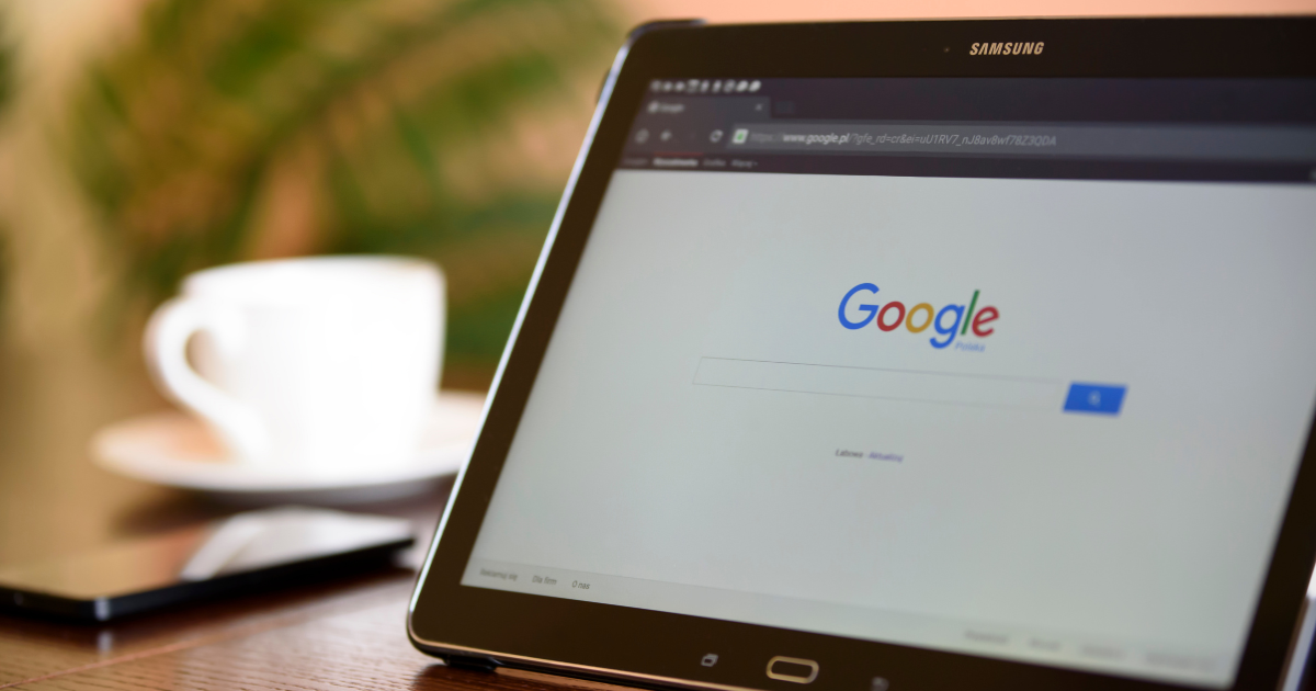 Google search page displayed on a tablet beside a coffee cup.